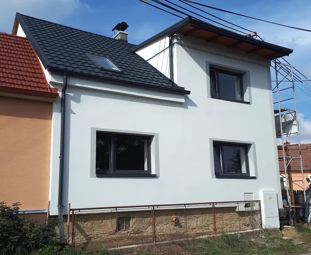 Dokončená světlá přední fasáda domu.