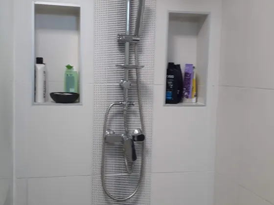 Dokončený sprchový kout se dvěma nikami a sprchovou sestavou.