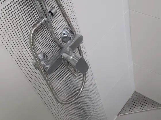 Detail sprchové sestavy a rohového odtoku.