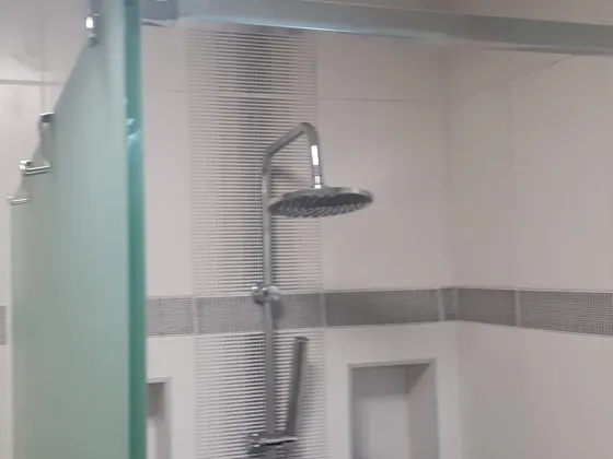 Velký sprchový kout se skleněnou zástěnou po dokončení.