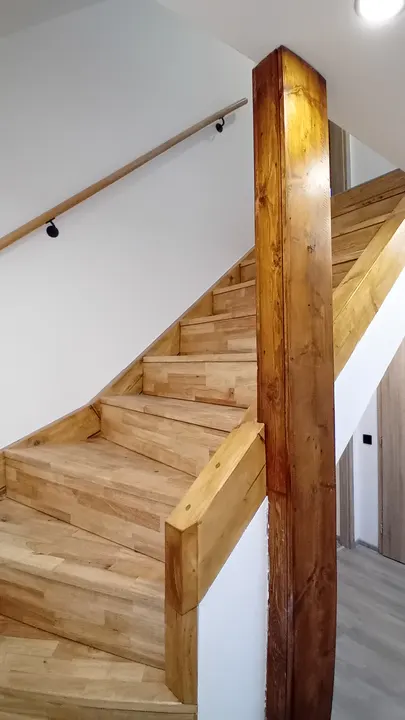 Dřevěné schodiště a přiznané konstrukční prvky domu.