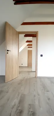 Chodba s vinylovou podlahou a dřevěnými dveřmi.