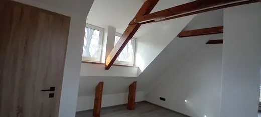 Přiznaný dřevěný trám v dokončeném interiéru.