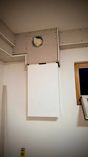 Zakrytí potrubí sádrokartonem v podkrovním interiéru.