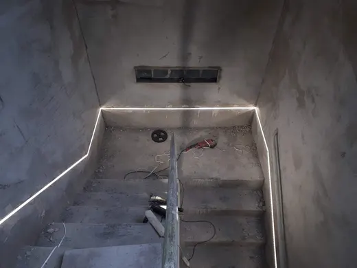 Pracovní fáze schodiště s vedením LED pásků podél stěn.