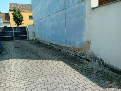 Poškozený soklový pás modré boční stěny před odkrytím.