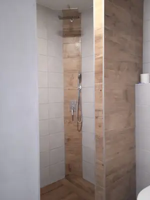 Pohled na dokončený sprchový kout a navazující prostor.